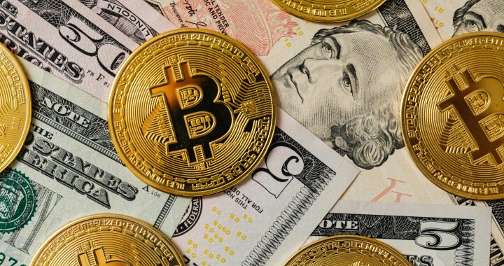 Golden bitcoins on a background of US dollar bills representing cryptocurrency and traditional money.