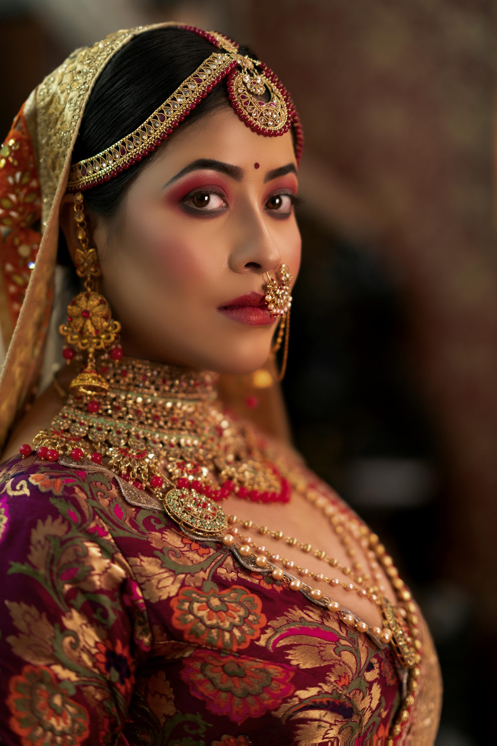 Portrait of an Indian bride showcasing intricate jewelry and traditional bridal attire.